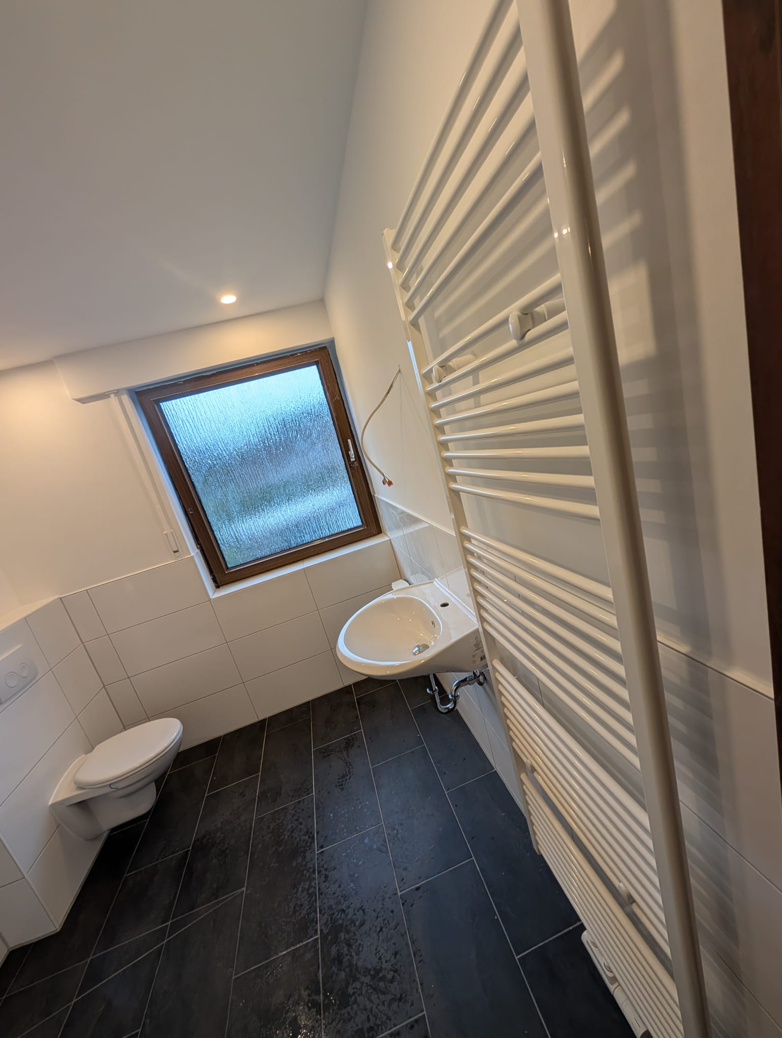 Helles Bad mit Handtuchheizk&ouml;rper und Fenster