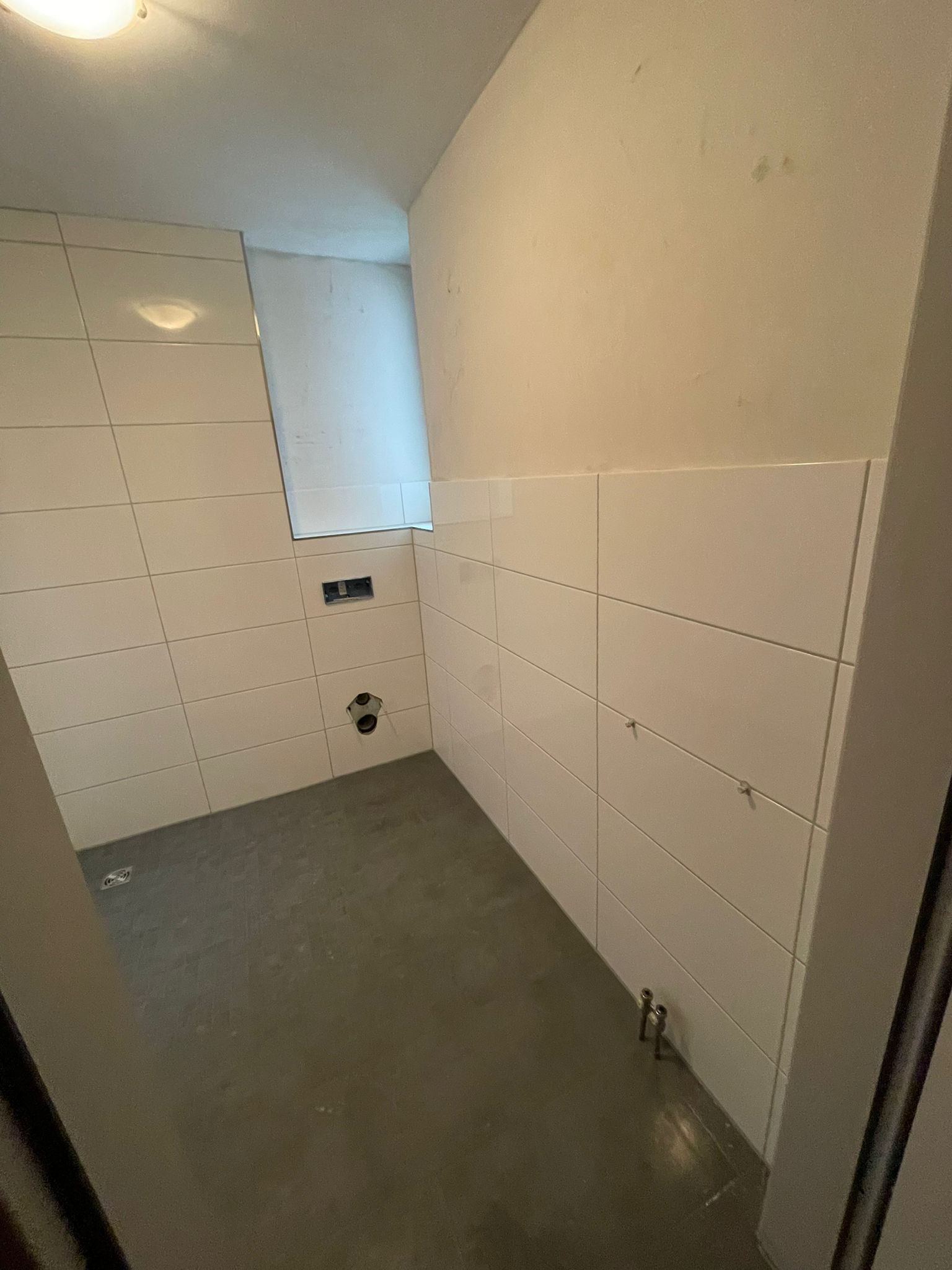Frisch geflieste W&auml;nde mit bodengleichem Bodenablauf