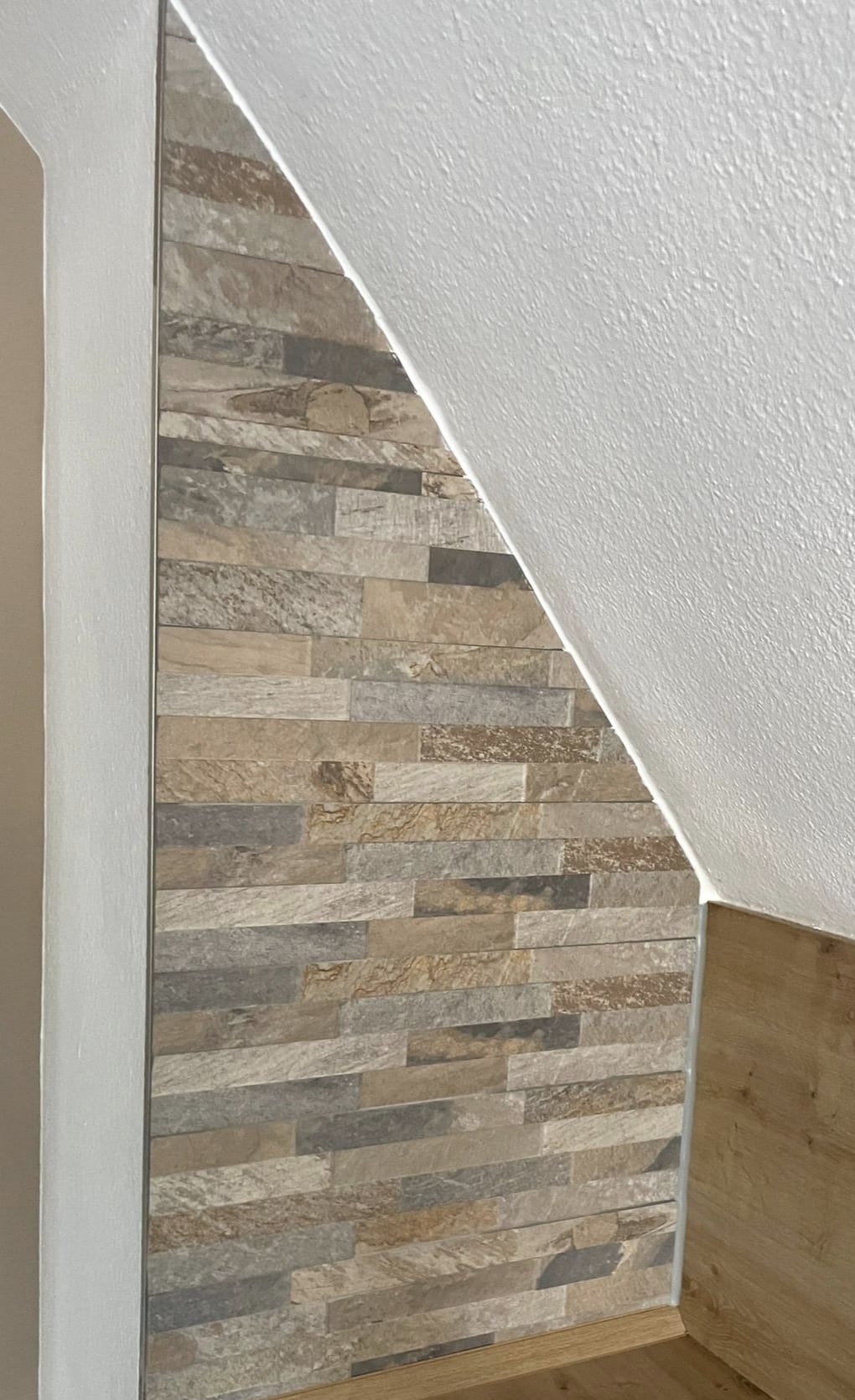 Akzentwand aus Naturstein-Riemchen unter der Dachschr&auml;ge